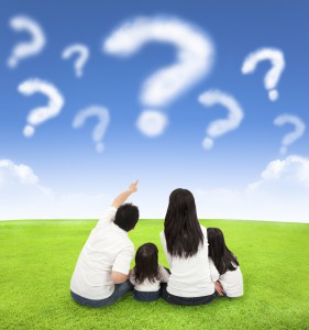 happy family sitting on a meadow with query of clouds