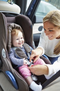 Mother Putting Baby Into Car Seat