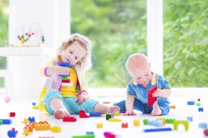 Brother and sister playing with colorful blocks